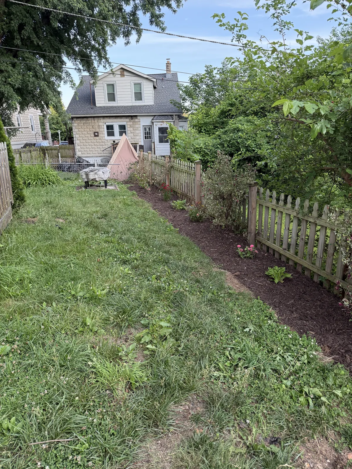 New picket fence installed with clean landscape behind it