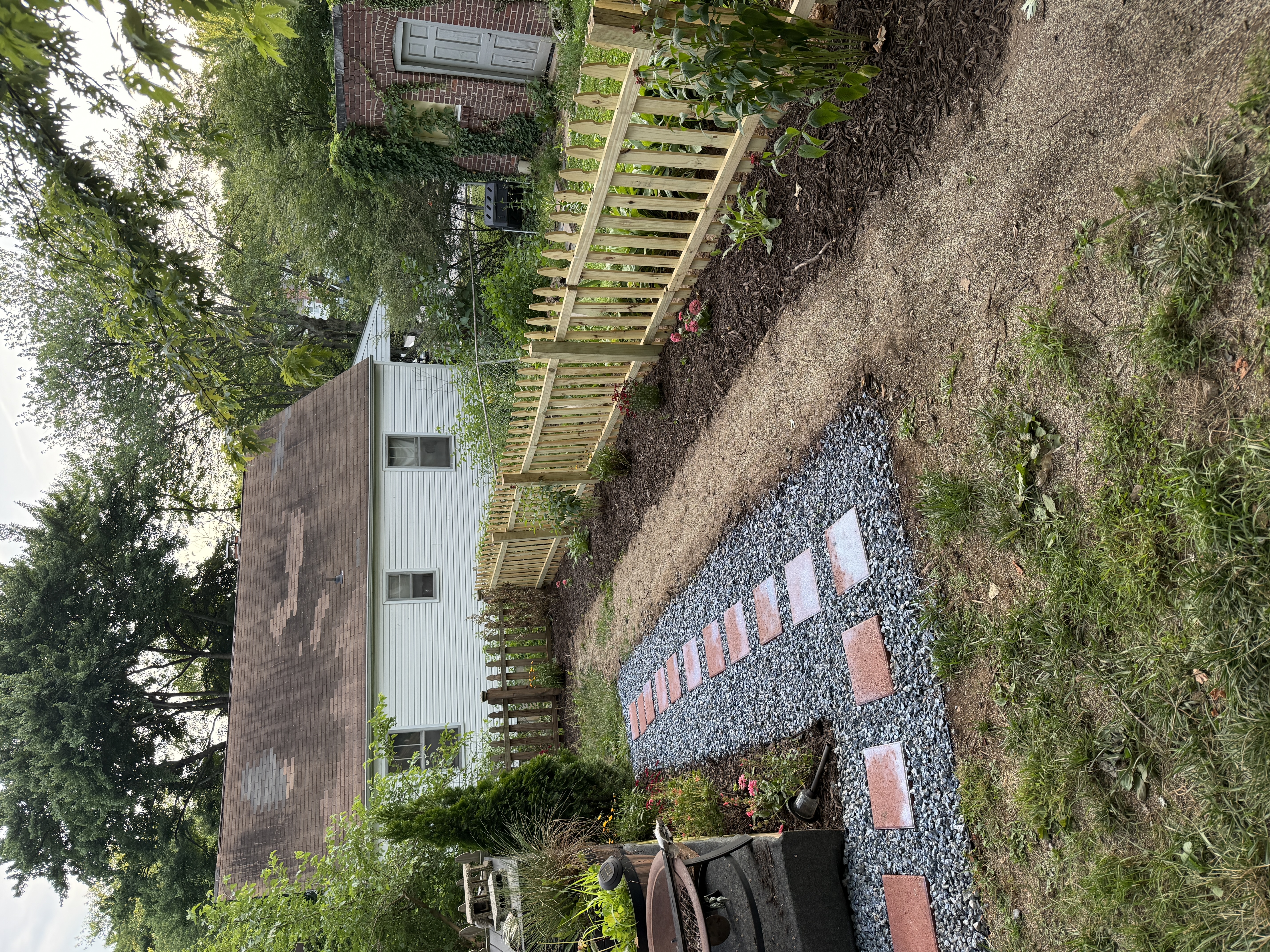 Completed fence with paver path and fresh mulch beds