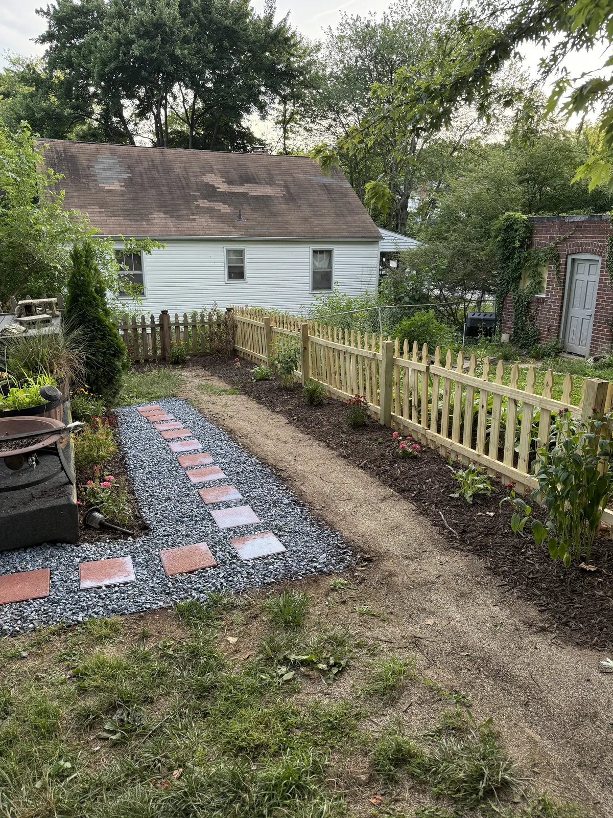 Completed fence with paver path and fresh mulch beds
